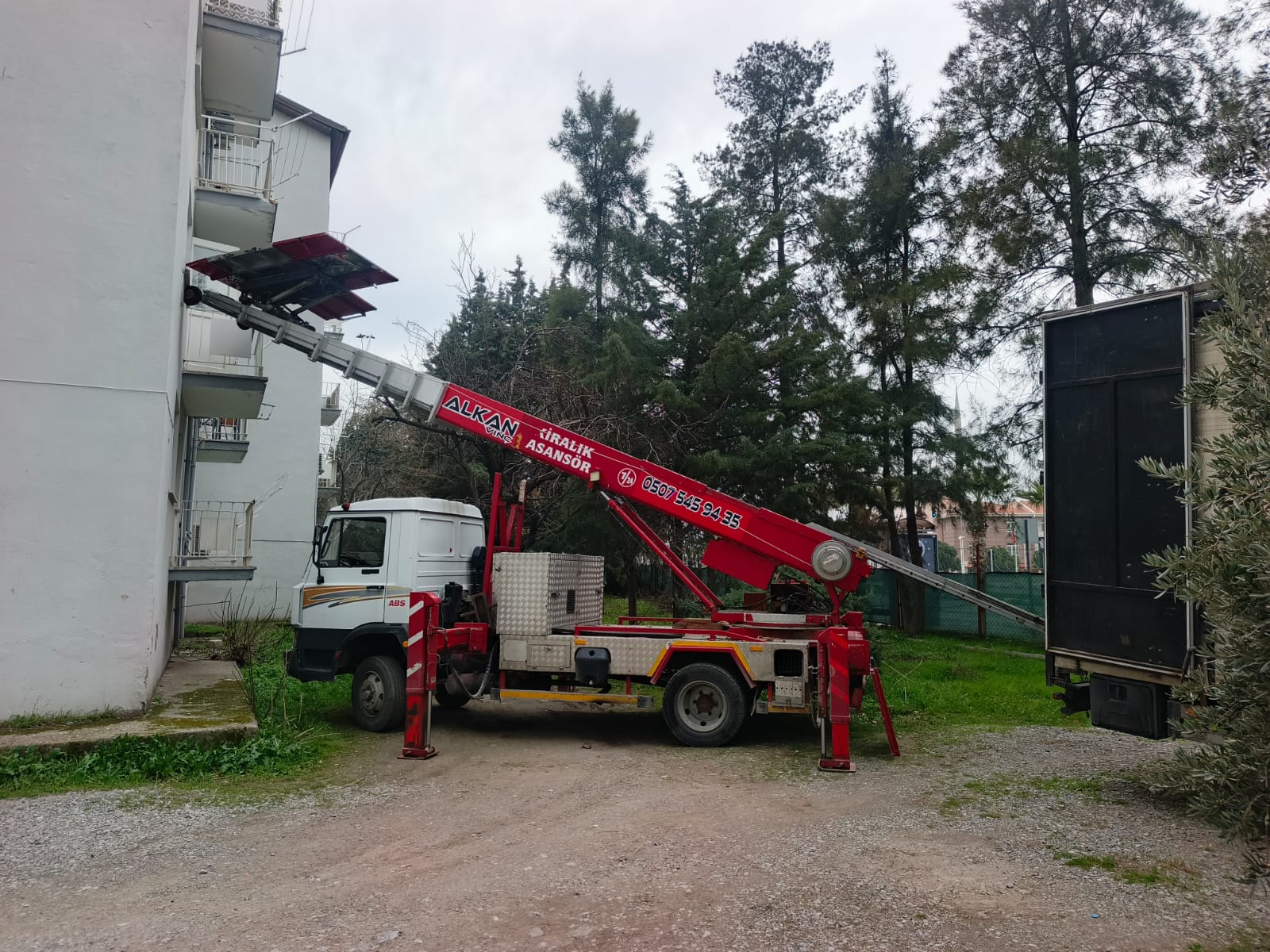 Balkona eşya taşıyan kırmızı kiralık asansör